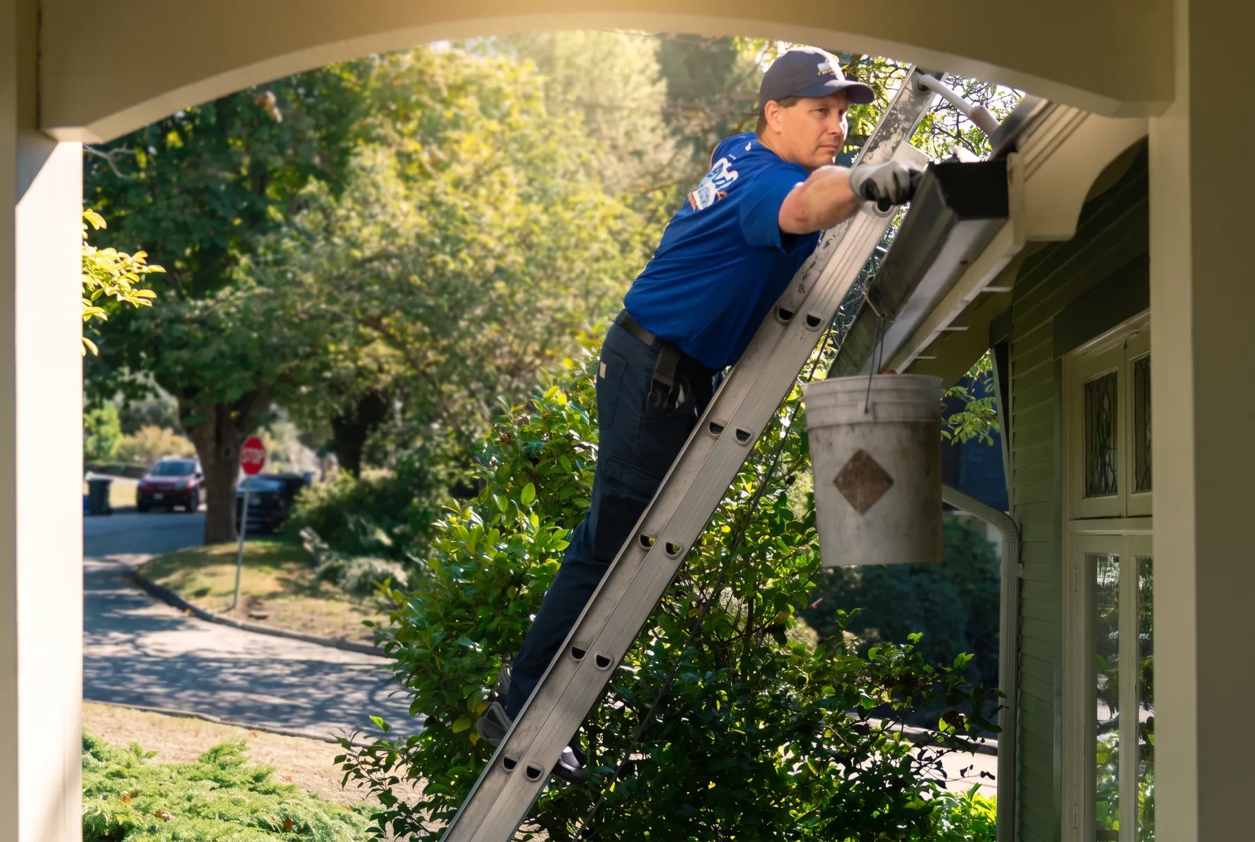 Holland Home Services crew cleaning a gutter from a ladder